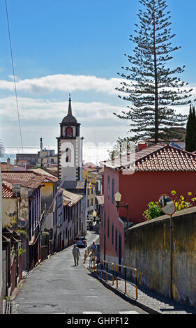 Narrow street leading down to city with sea in background. Funchal, Madeira, Portugal Stock Photo