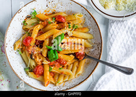 Penne pasta and arrabbiata sauce with cherry tomatoes Stock Photo