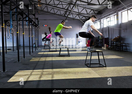 Athletes doing box jumps in gym Stock Photo