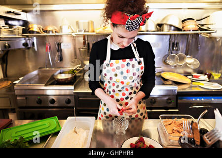 Female chef preparing food in commercial kitchen Stock Photo