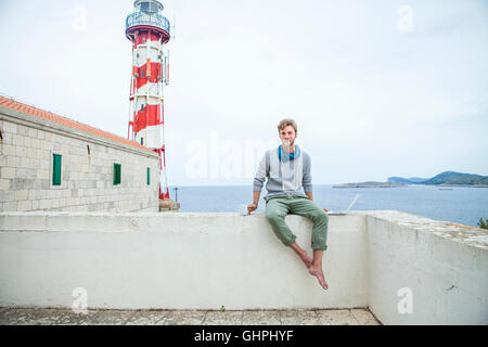 Young man with laptop and cup of coffee at the seaside Stock Photo