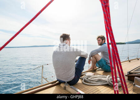 Two men on boat deck of yacht talking Stock Photo