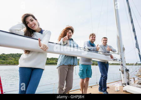 Friends on yacht giving the thumbs-up Stock Photo
