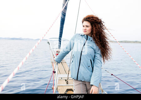 Young woman on bow of yacht Stock Photo