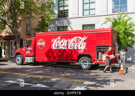 A delivery man unloads a Coca-Cola beverage truck on Meeting Street in Charleston, South Carolina. Stock Photo