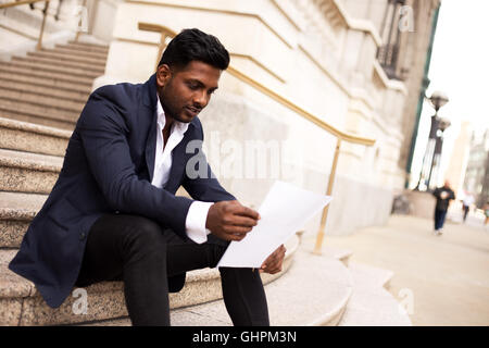 Business man in the street reading a letter Stock Photo