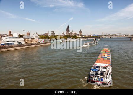 Container ship and cruise ship at the Rhine river in Cologne, Germany Stock Photo
