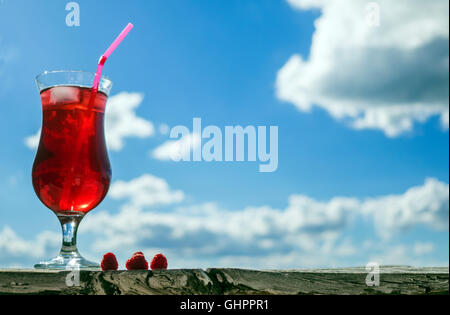 Raspberry and lemonade against blue sky with clouds Stock Photo
