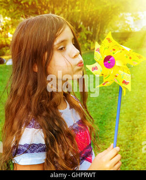 Little girl blowing on a windmill Stock Photo
