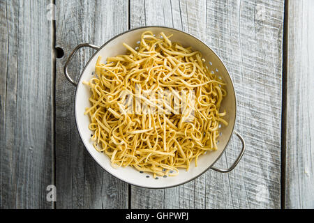 Tasty spaetzle pasta in colander. Stock Photo