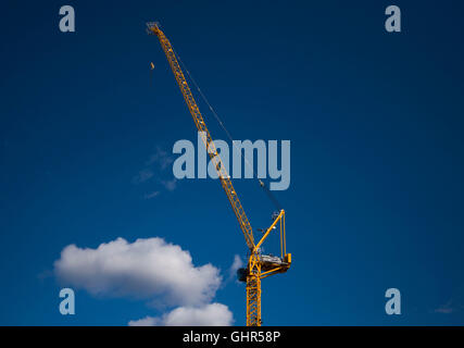 Cranes on a housing construction site with a blue sky background. Stock Photo