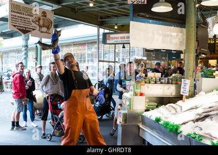 Seattle, Washington: Ryan catches a fish at Pike Place Fish Market. Stock Photo