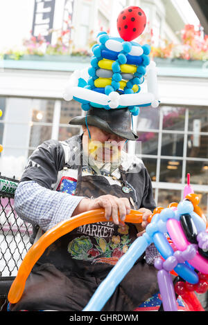Seattle, Washington: Twister Thomas models balloons at Pike Place Market. Stock Photo