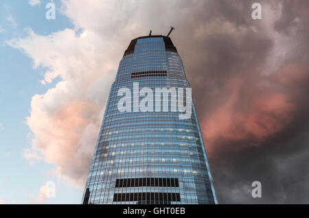 Goldman Sachs skyscraper in Jersey City with dark and red storm clouds behind at sunset Stock Photo