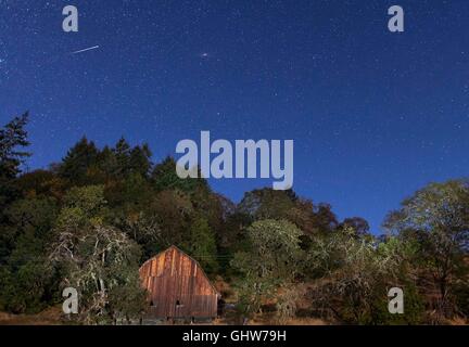 Roseburg, Oregon, USA. 11th Aug, 2016. A meteor from the Perseid meteor shower streaks through the sky over a barn on a farm near Roseburg. The Perseid meteor shower is is expected to peak early Friday morning when as many as 200 meteors per hour may streak across the night sky. © Robin Loznak/ZUMA Wire/Alamy Live News Stock Photo