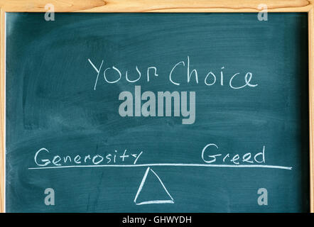 the words generosity and greed on a scale in equilibrium written on a chalkboard. Stock Photo