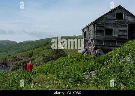 Alaska, Aleutian Islands, Unga Island, Unga Village. Expedition tourists exploring abandoned gold mining village. Stock Photo