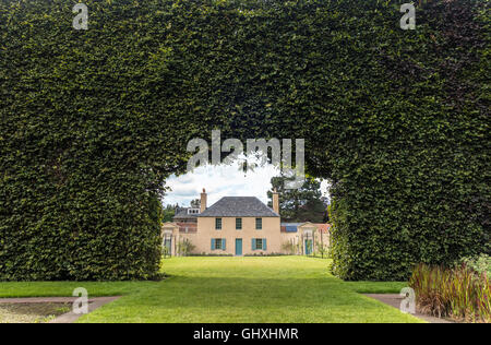 Royal Botanic Garden Edinburgh RBGE. Historic Botanical Cottage seen through the famous century-old Beech Hedge 8m - 23ft high. Stock Photo