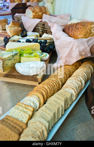 Vertical view of a selection of cheeses on a cheeseboard with accompaniments.