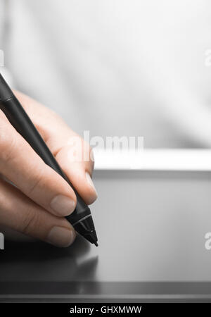 Close up of the hand of a graphic designer holding an electronic stylus. Background with free space for text, vertical image Stock Photo