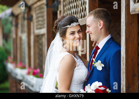 Wedding couple in the backdrop of wooden garden house Stock Photo