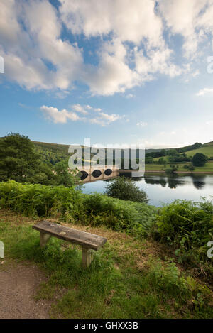 A bench with views of Ashopton viaduct and the calm waters of Ladybower reservoir in the Peak District, England. Stock Photo