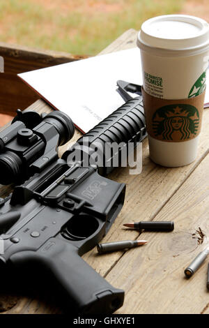 Smith & Wesson AR-15 style rifle and coffee cup on shooting bench at Leeds Range in Carlisle, SC Stock Photo