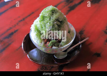 Green tea and red beans Kakigori, Japanese shaved ice dessert flavoured with syrup and condensed milk. Stock Photo