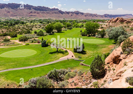 A pair of golfers on the 14th Green of the picturesque Moab Golf Course nestled amongst the red rocks in Moab, Utah. Stock Photo