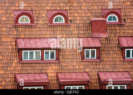Old house tiled roof with many attic windows Stock Photo