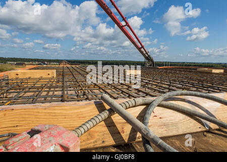 Workers poured concrete using a concrete pump with a vibrator. Stock Photo