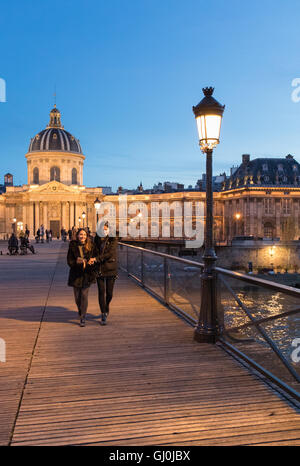 Figures on Pont des Arts at dusk, Paris, France Stock Photo