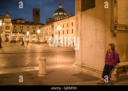 Wendy waiting in Piazza della Loggia at dusk, Brescia, Lombardy, Italy Stock Photo