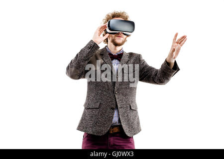 Young curly-haired businessman wearing brown suit use a VR headset and experiencing virtual reality isolated on white background Stock Photo
