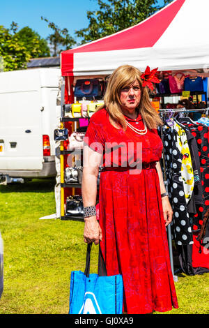 Transvestite man in a dress transgender male wearing red dress long hair wig trying to look like woman UK England GB Stock Photo