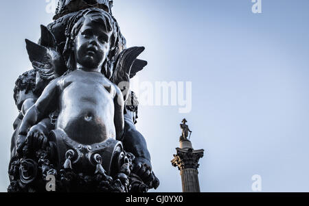 View of Nelson's column and cherubic detail from a lamp post in Trafalgar Square, London, UK. Stock Photo