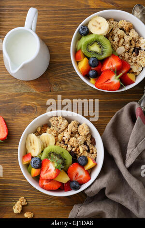 Two bowls with fruits granola and jug of milk. Food top view. Stock Photo