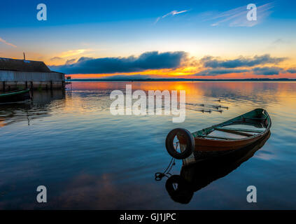 Sunrise on Lake Seliger with an old boat in the foreground, Ostashkov, Tver region, Russia. Stock Photo