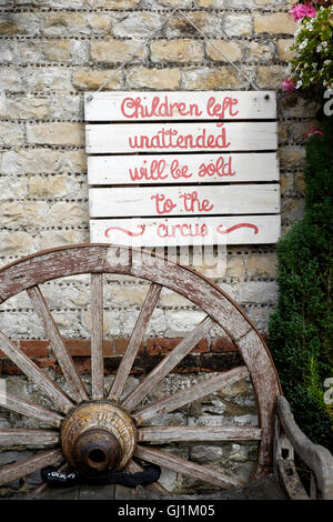 joking passive sign stating children left unattended will be sold to the circus at a traditional uk country pub