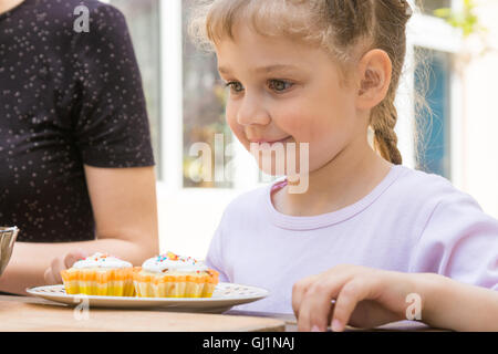 Happy girl is preparing to eat Easter cupcakes Stock Photo