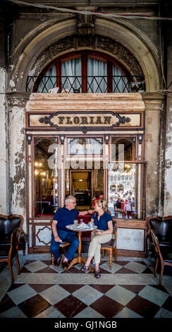 Mature couple sitting outside Caffe Florian having coffee. Venice. Italy. Stock Photo