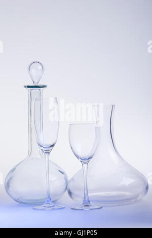 Empty decanters with wine glass and clipping path on light-blue background. Stock Photo