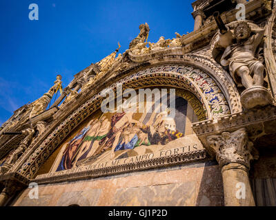 Close up of the carved stone work surrounding the mosaiced lunette on the exterior of the upper register of St Mark's basilica.  Stock Photo