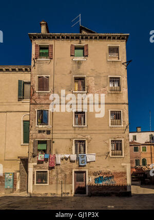 Traditional venetian rendered building. with window shutters, venetian blinds. and laundry hanging from a washing-line. Venice, Stock Photo