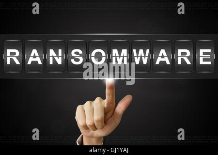 business hand pushing ransomware on Flipboard Display Stock Photo