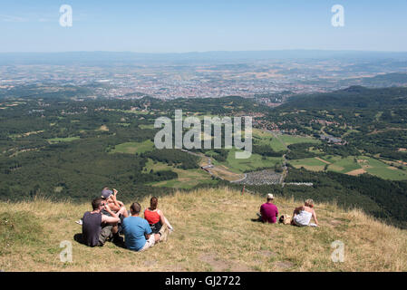 Families sat enjoying the view from the summit of Puy de Dome volcano in the Auvergne region of France Stock Photo