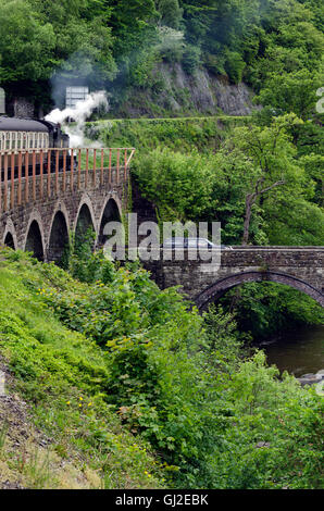 Steam tank locomotive pulling a train on a bridge over the River Dee near Llangollen in North Wales. Stock Photo