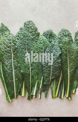 Kale leaves. A bunch of green fresh kale on a wet surface. Top view, vintage toned image, blank space Stock Photo