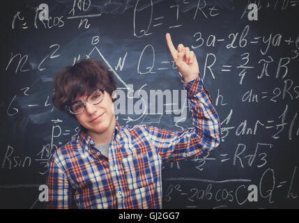 Boy and blackboard filled with math formulas Stock Photo