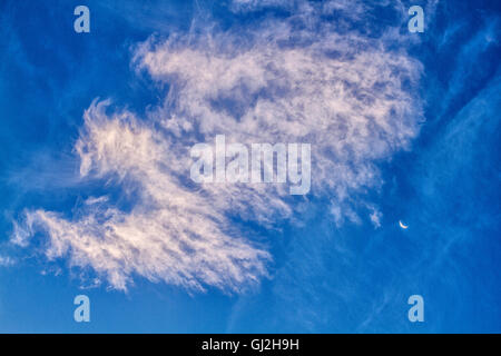 Clouded sky with crescent moon. Stock Photo